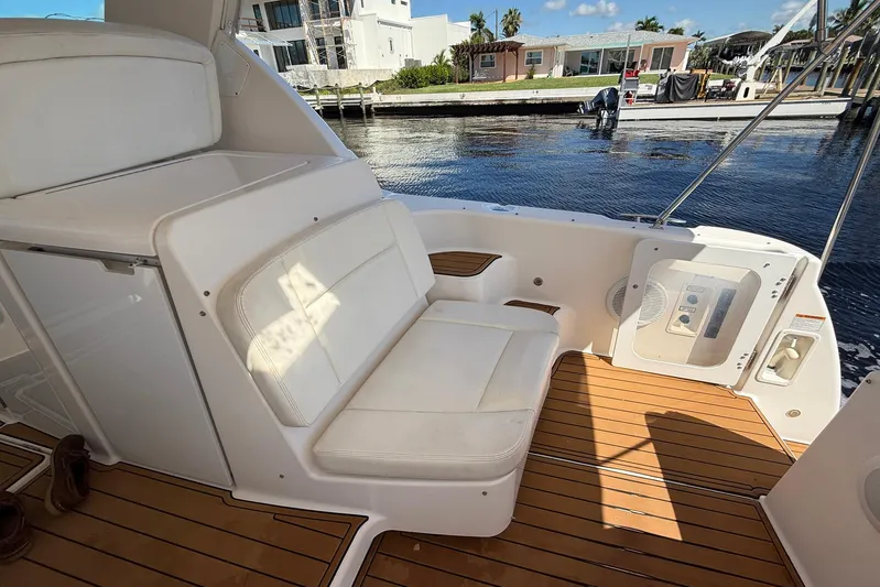 Blue Skys Yacht Photos Pics 2005 Tiara Yachts 3600 Sovran cockpit with white seating and teak flooring by the water.