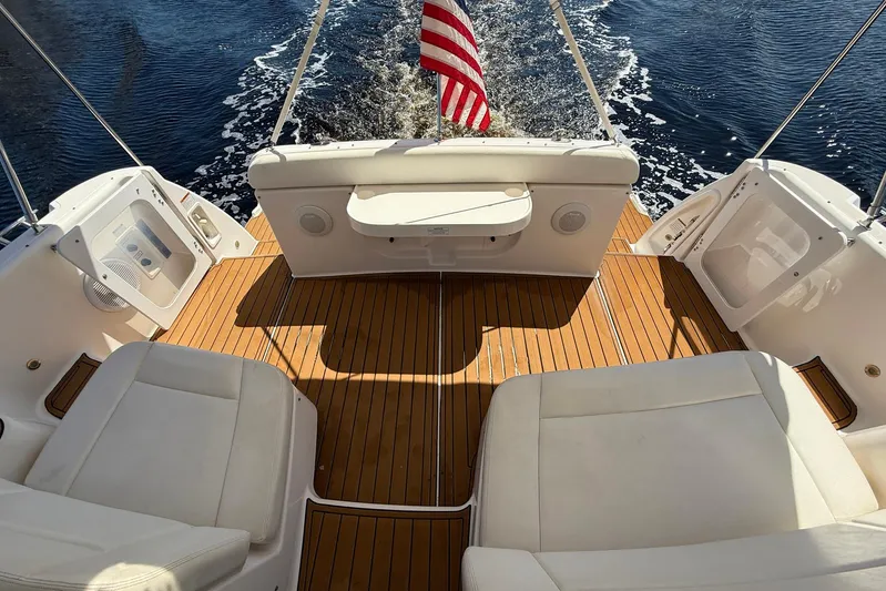 Blue Skys Yacht Photos Pics 2005 Tiara Yachts 3600 Sovran cockpit with teak flooring and white seating, cruising on water.