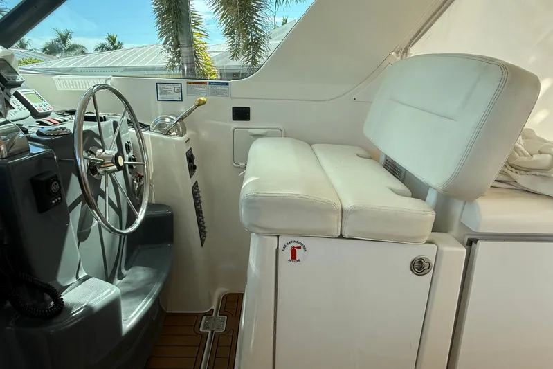 Blue Skys Yacht Photos Pics 2005 Tiara Yachts 3600 Sovran helm with steering wheel and white seating.