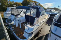 2008 Nimbus 27 Nova S boat docked with blue canopy and chrome railings.