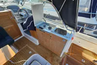 Interior of 2008 Nimbus 27 Nova S boat with steering wheel, stove, and sink.