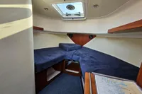 Interior cabin of 2008 Nimbus 27 Nova S boat with blue cushions and skylight.