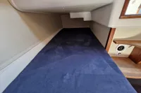 Interior cabin of 2008 Nimbus 27 Nova S boat with blue bedding.