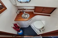 2008 Nimbus 27 Nova S boat bathroom with wooden accents and stainless steel sink.