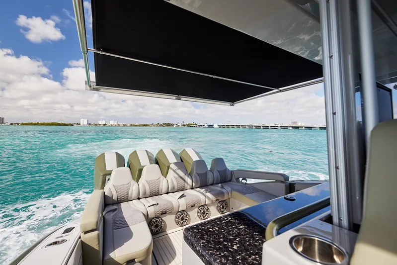  Yacht Photos Pics 2025 Midnight Express 52' Vitesse yacht cruising on turquoise waters under a sunny sky.