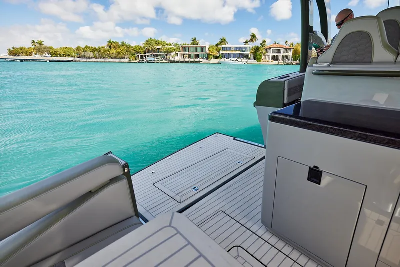  Yacht Photos Pics 2025 Midnight Express 52' Vitesse yacht on turquoise water near luxury waterfront homes.