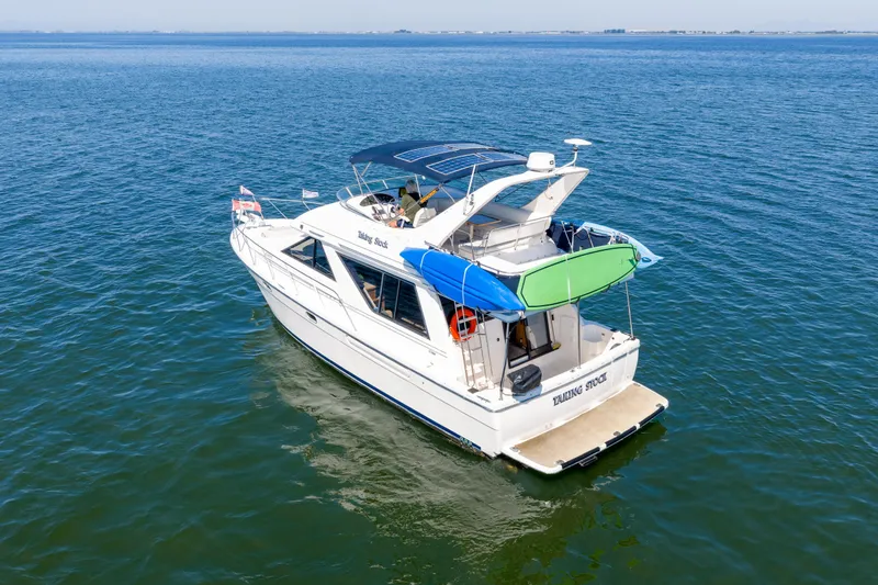  Yacht Photos Pics 1997 Bayliner 3988 yacht cruising on open water, featuring kayaks and a spacious deck.