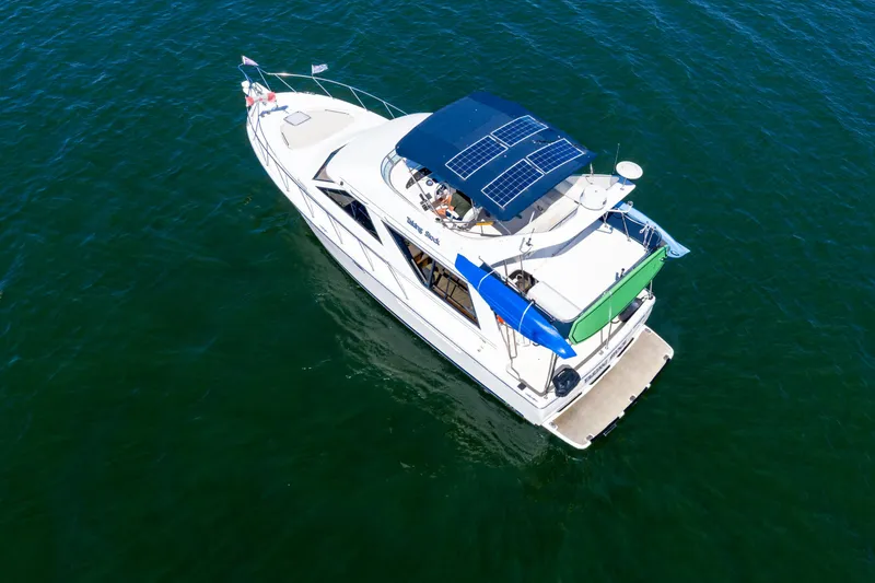  Yacht Photos Pics Aerial view of a 1997 Bayliner 3988 yacht with solar panels on open water.