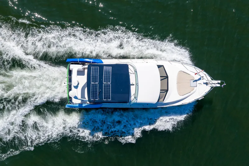  Yacht Photos Pics Aerial view of 1997 Bayliner 3988 yacht with solar panels cruising on water.