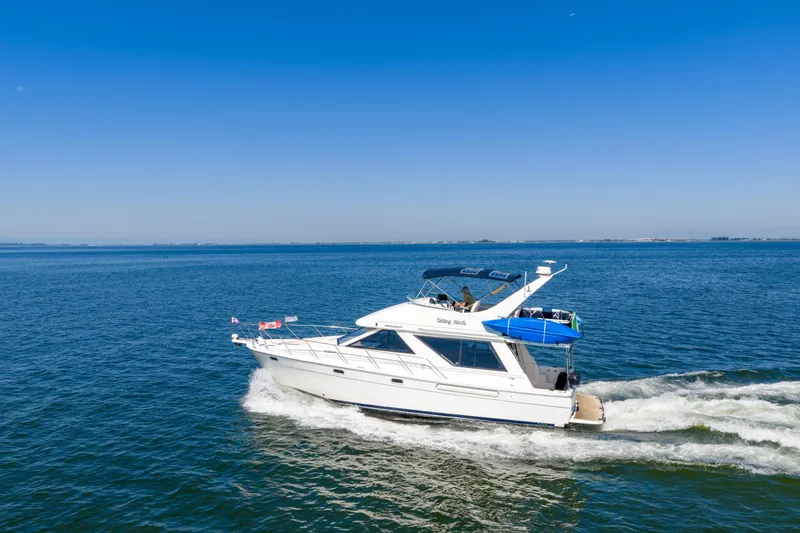  Yacht Photos Pics 1997 Bayliner 3988 cruising on open water under clear blue skies.