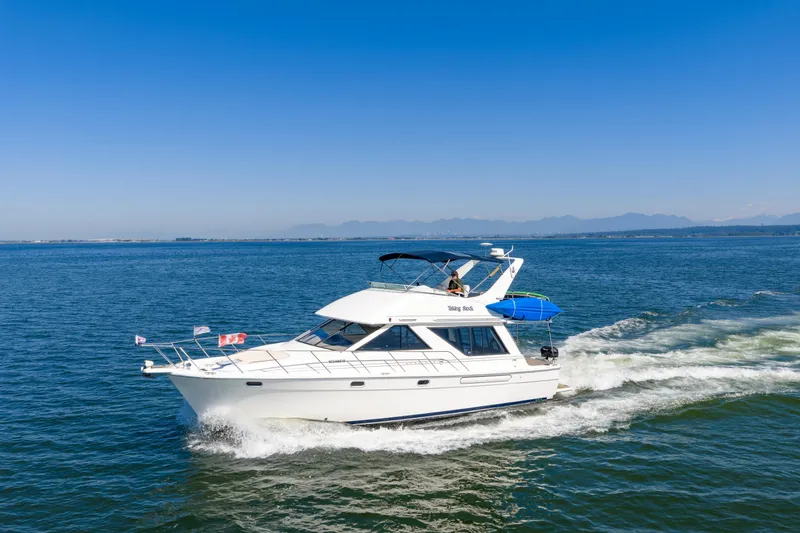  Yacht Photos Pics 1997 Bayliner 3988 yacht cruising on open water under clear blue sky.