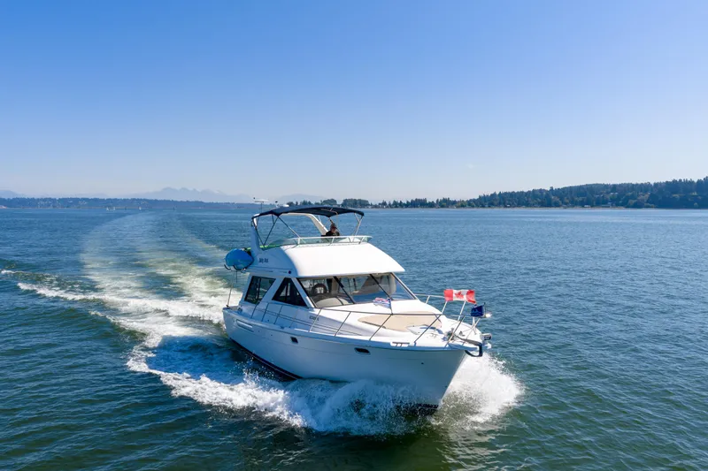  Yacht Photos Pics Bayliner 3988 yacht cruising on a sunny day, 1997 model, open water background.