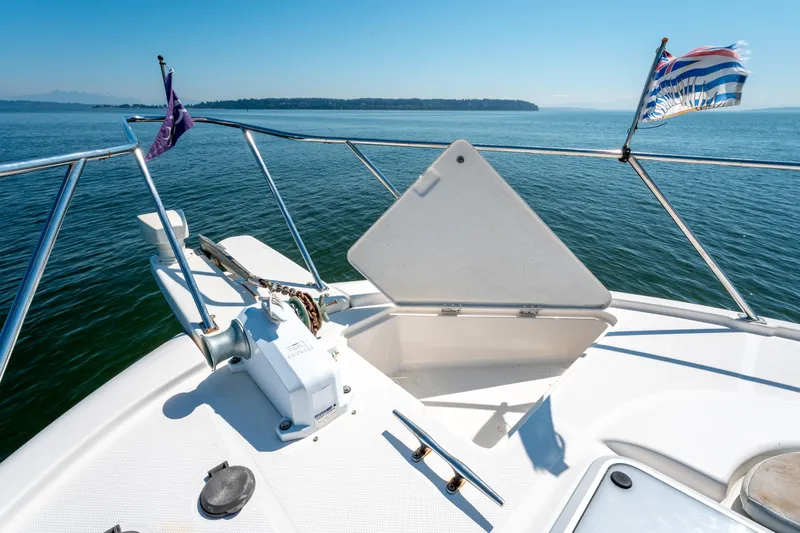  Yacht Photos Pics 1997 Bayliner 3988 yacht bow with flags, open hatch, and scenic ocean view.