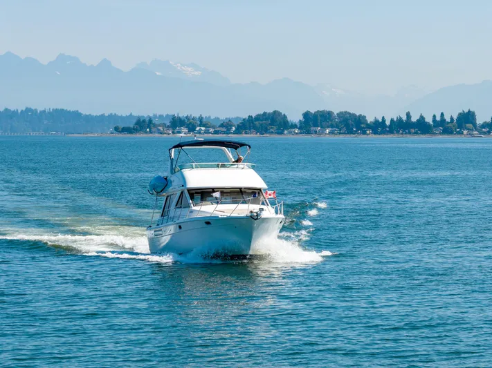  Yacht Photos Pics 1997 Bayliner 3988 yacht cruising on a serene blue lake with distant mountains.