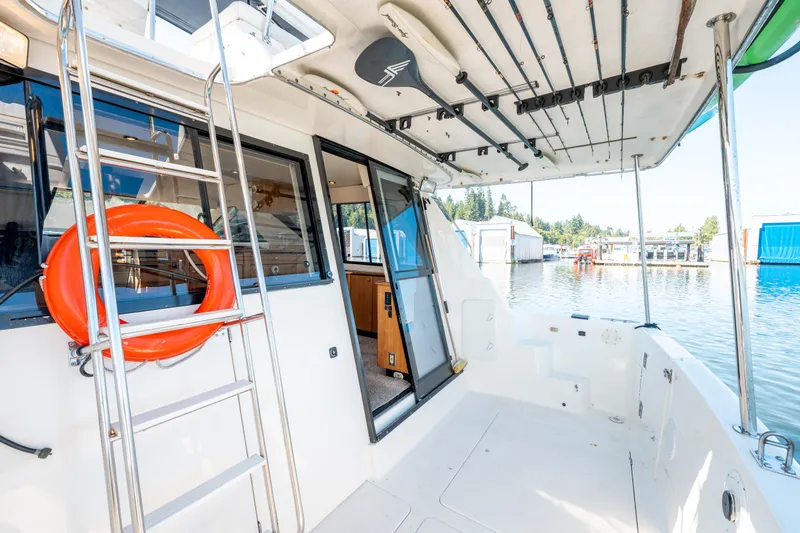  Yacht Photos Pics 1997 Bayliner 3988 boat deck with ladder, life preserver, and fishing rod holders.