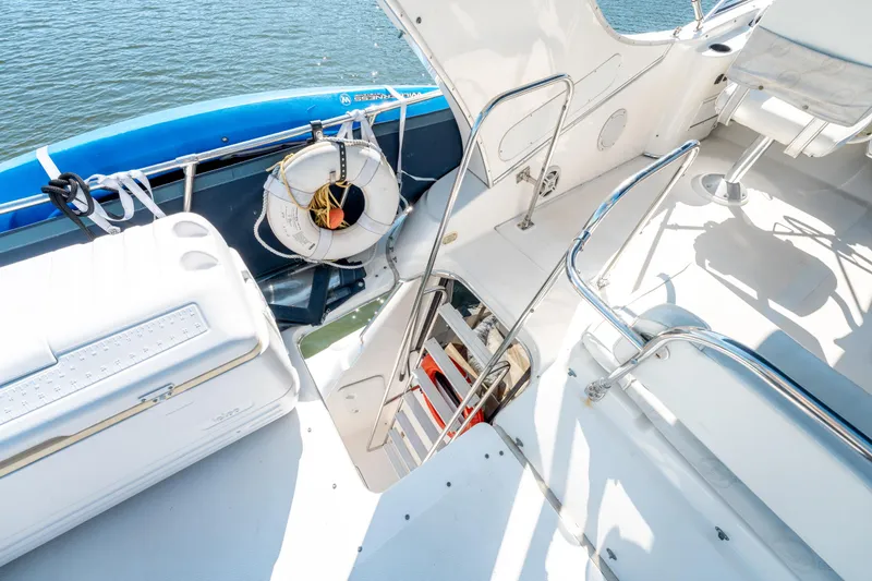  Yacht Photos Pics 1997 Bayliner 3988 boat deck with seating, life preserver, and water view.