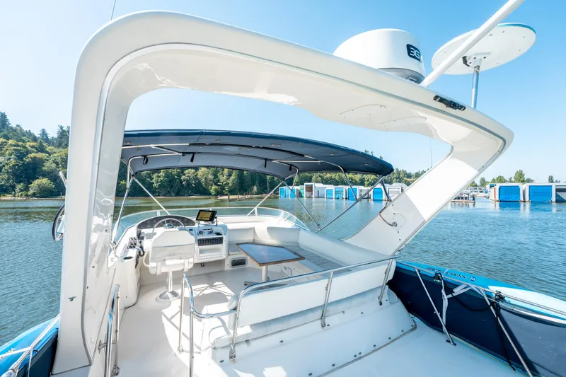  Yacht Photos Pics 1997 Bayliner 3988 yacht cockpit with helm, seating, and canopy on a sunny day.