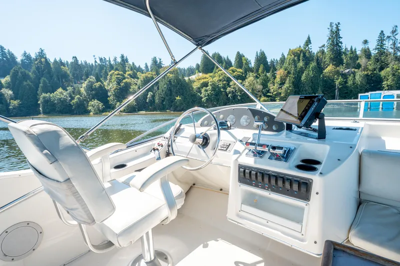  Yacht Photos Pics 1997 Bayliner 3988 yacht helm with steering wheel, controls, and navigation system on a scenic lake.