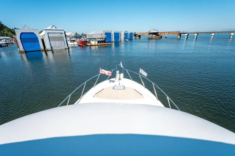  Yacht Photos Pics Bow view of 1997 Bayliner 3988 yacht approaching marina with blue boat sheds.