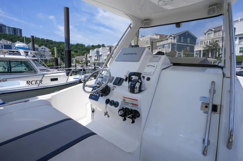  Yacht Photos Pics 2020 Belzona 27 Walkaround boat helm with Garmin navigation, docked near waterfront homes.