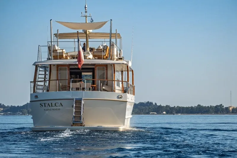 Stalca Yacht Photos Pics Classic 1971 Visch 001 yacht cruising on calm waters, rear view.