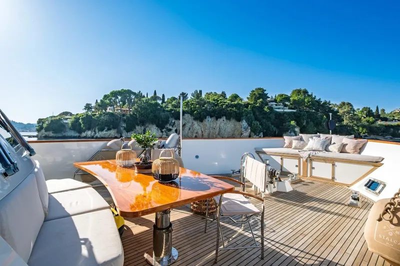 Stalca Yacht Photos Pics Luxurious Visch 001 yacht deck, 1971 model, with elegant seating and scenic coastal view.