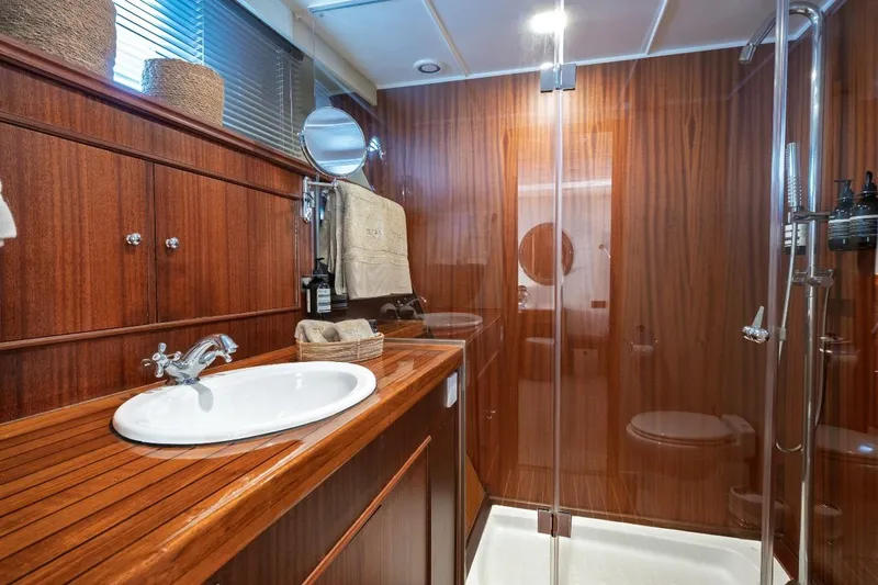 Stalca Yacht Photos Pics Luxurious wooden bathroom interior in 1971 Visch 001 yacht, featuring sink and glass shower.