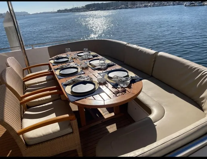 Sand Castle Yacht Photos Pics Outdoor dining setup on a 1996 Johnson 70 Euro yacht, overlooking serene waters.
