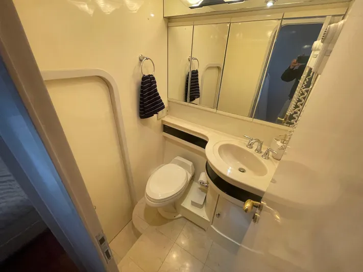 Sand Castle Yacht Photos Pics Compact bathroom in a 1996 Johnson 70 Euro yacht, featuring a toilet, sink, and mirror.