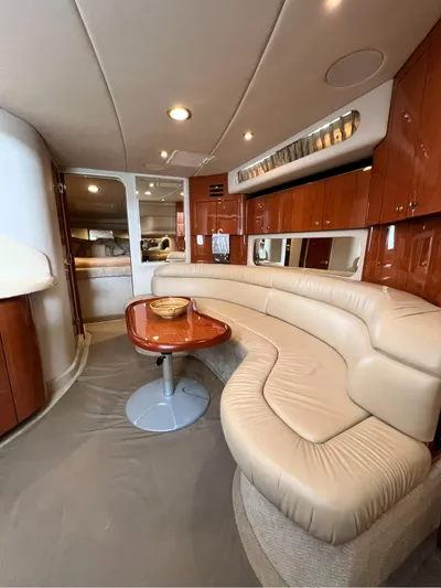  Yacht Photos Pics Interior of 2001 Sea Ray 380 Sundancer with curved leather seating and wooden table.