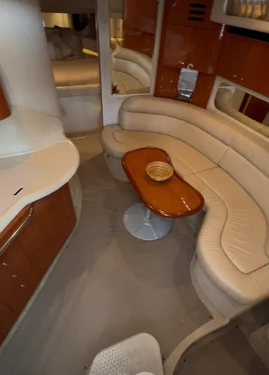  Yacht Photos Pics Interior of 2001 Sea Ray 380 Sundancer with curved seating and wooden table.