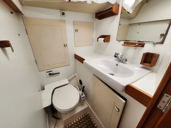 Vivace 1 Yacht Photos Pics Hallberg-Rassy 36 MKII 2002 yacht bathroom with sink, toilet, and storage cabinets.
