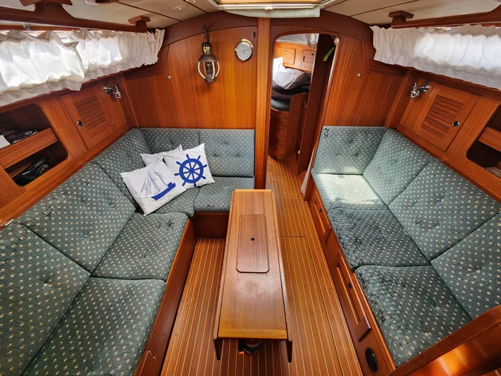 Vivace 1 Yacht Photos Pics Interior of 2002 Hallberg-Rassy 36 MKII sailboat with cozy seating and nautical decor.