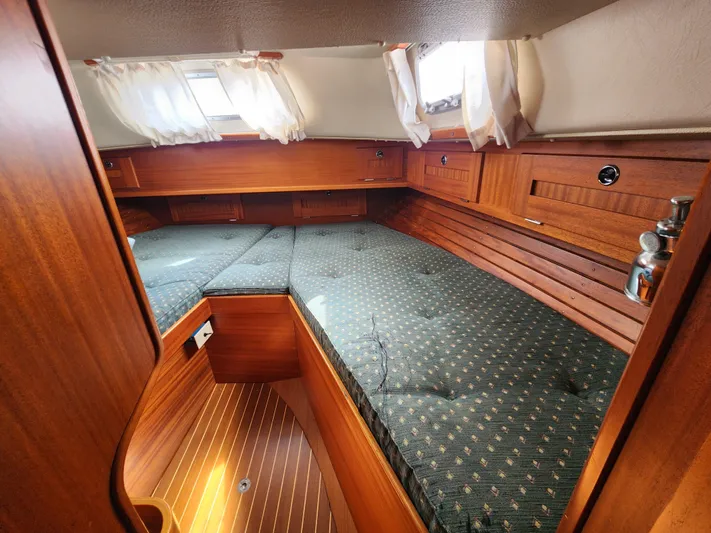 Vivace 1 Yacht Photos Pics Cozy cabin interior of 2002 Hallberg-Rassy 36 MKII sailboat with wooden finish and cushioned berth.