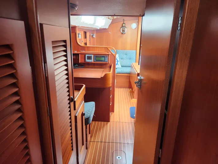 Vivace 1 Yacht Photos Pics Interior of 2002 Hallberg-Rassy 36 MKII yacht, featuring wooden cabinetry and blue seating.