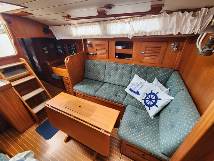 Vivace 1 Yacht Photos Pics Interior of 2002 Hallberg-Rassy 36 MKII yacht with cozy seating and nautical decor.