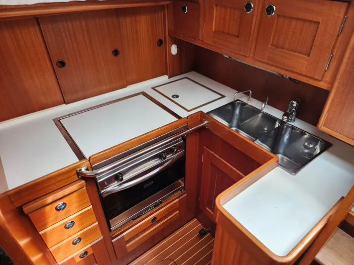 Vivace 1 Yacht Photos Pics Galley kitchen in 2002 Hallberg-Rassy 36 MKII yacht with wood cabinetry and stainless steel sink.
