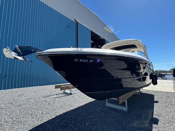  Yacht Photos Pics 2019 Sea Ray SLX 310 boat displayed outdoors near a blue warehouse.