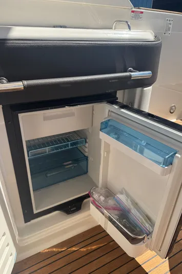  Yacht Photos Pics 2019 Sea Ray SLX 310 boat refrigerator with open door, showing interior shelves.