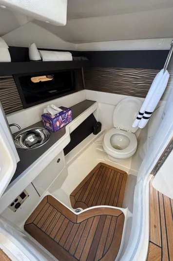  Yacht Photos Pics 2019 Sea Ray SLX 310 boat bathroom with sink, toilet, and wooden flooring.