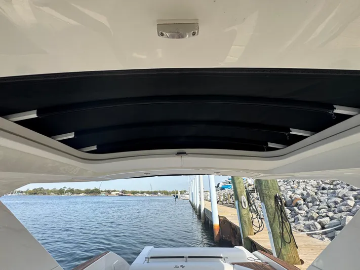  Yacht Photos Pics 2019 Sea Ray SLX 310 boat with open sunroof, docked by a scenic waterfront.