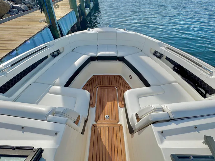  Yacht Photos Pics 2019 Sea Ray SLX 310 boat with spacious seating and wooden deck, docked by the water.