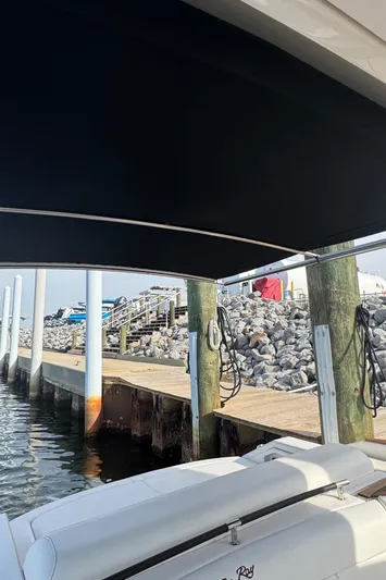 Yacht Photos Pics 2019 Sea Ray SLX 310 docked near rocky shoreline under canopy.