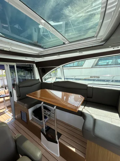  Yacht Photos Pics 2014 Cruisers Yachts 41 Cantius interior with skylight, sleek seating, and wooden table.