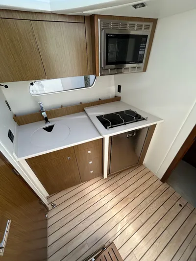  Yacht Photos Pics 2014 Cruisers Yachts 41 Cantius kitchen with stove, microwave, and wooden cabinetry.