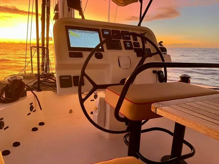  Yacht Photos Pics Sunreef 62 yacht helm with sunset view, 2018 model, featuring navigation equipment and seating.