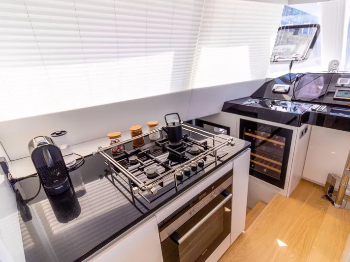  Yacht Photos Pics Modern kitchen interior on 2018 Sunreef 62 yacht with stove, oven, and wine cooler.