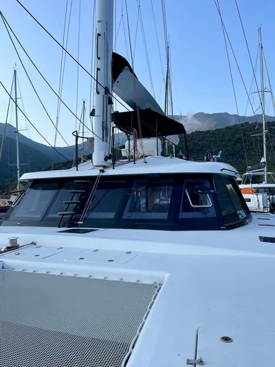  Yacht Photos Pics 2018 Sunreef 62 yacht docked, featuring sleek design and spacious deck, surrounded by mountains.