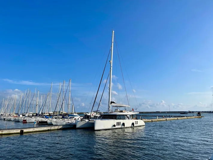  Yacht Photos Pics 2018 Sunreef 62 catamaran docked in a marina under a clear blue sky.