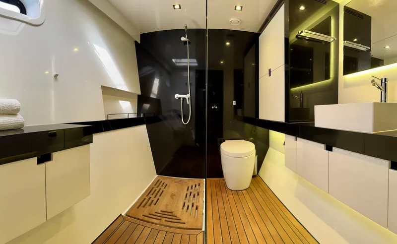  Yacht Photos Pics Luxurious bathroom interior of 2018 Sunreef 62 yacht with modern fixtures and wooden flooring.